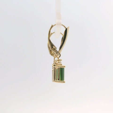Close-up of gold earrings with green stone, side view